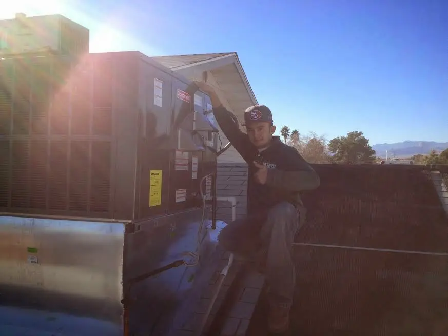 HVAC technician performing AC Tune-Up on a rooftop unit in Mendota Heights